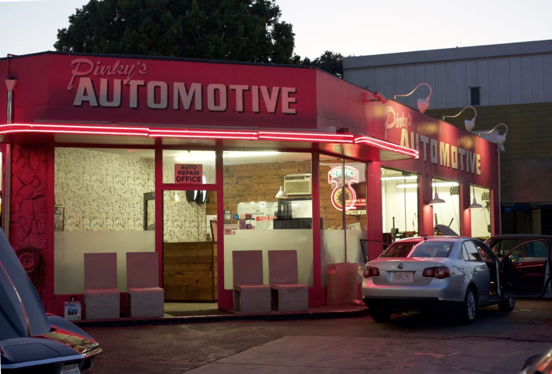 Pinky's Automotive neon-lit shop exterior in Hollywood, CA at dusk