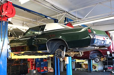 Vehicle suspension and brake components on a lift at Pinky's Automotive